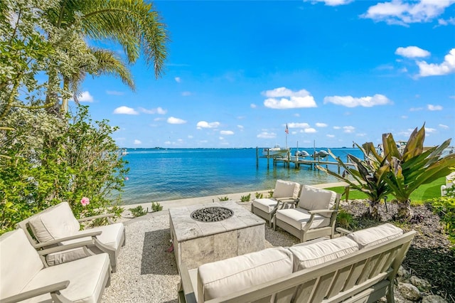 property view of water featuring a fire pit, a boat dock, and a view of the beach