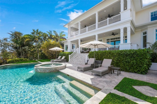 view of swimming pool featuring pool water feature, an in ground hot tub, and a patio