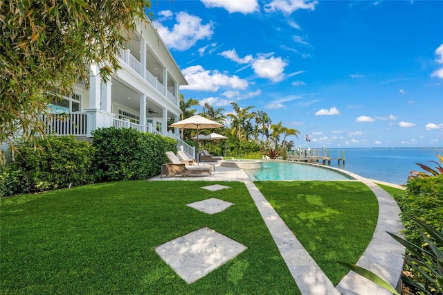 view of pool featuring a lawn, a patio area, and a water view