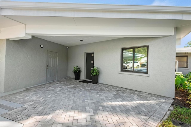 entrance to property featuring a patio and stucco siding