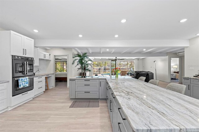 608 69th Ave W, Bradenton, FL 34207 - kitchen with recessed lighting, light wood-style flooring, beam ceiling, light stone countertops, and open floor plan