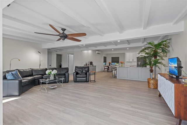 living room featuring beamed ceiling, a wall mounted AC, light hardwood / wood-style flooring, and ceiling fan