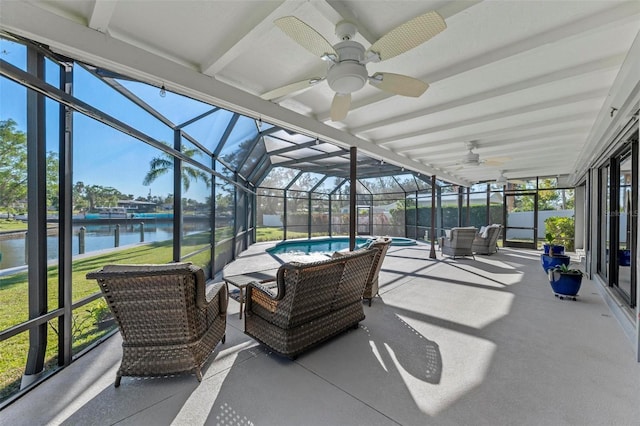 sunroom featuring ceiling fan and a water view