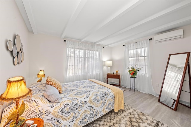 bedroom with a wall mounted air conditioner, beamed ceiling, and light wood finished floors