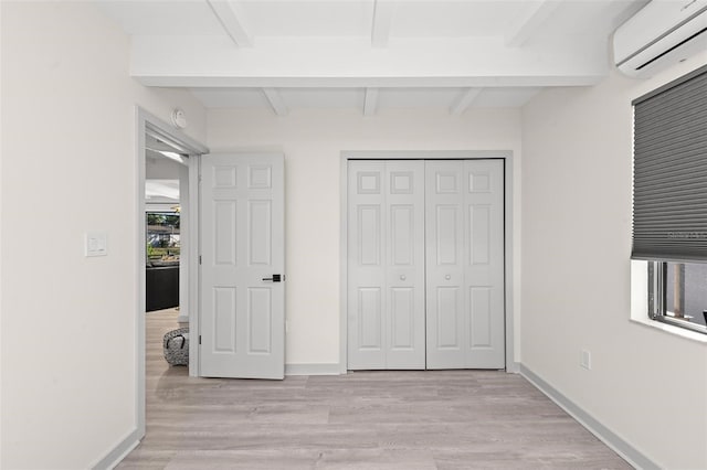 608 69th Ave W, Bradenton, FL 34207 - unfurnished bedroom with a wall mounted AC, beam ceiling, light wood-style flooring, and a closet