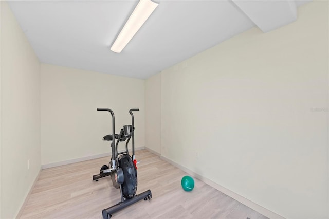 workout room with light wood-type flooring and baseboards