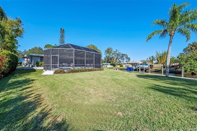 view of yard featuring a water view and glass enclosure