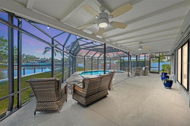 sunroom with a water view, plenty of natural light, and ceiling fan