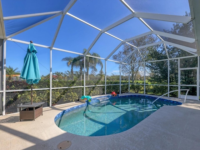 view of swimming pool featuring glass enclosure and a patio area