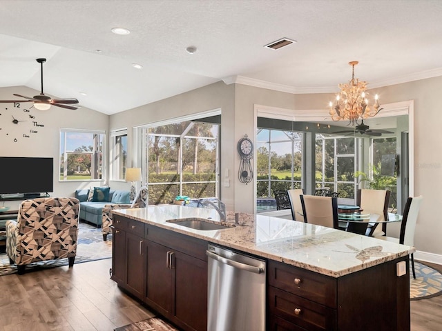 kitchen featuring sink, vaulted ceiling, stainless steel dishwasher, light hardwood / wood-style floors, and light stone counters