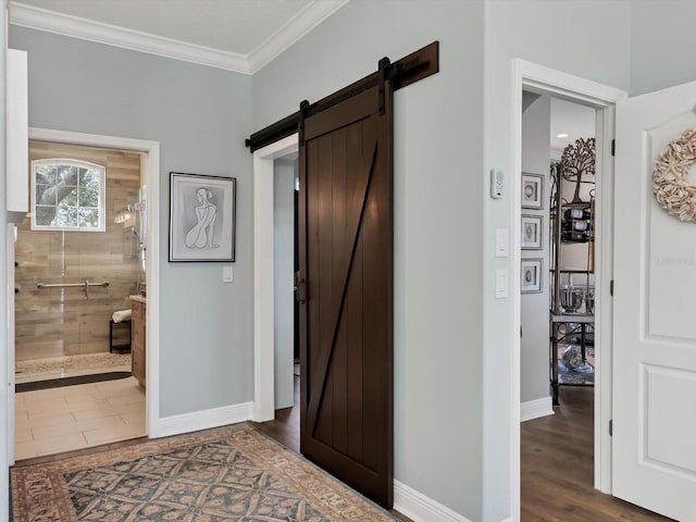 hall with a barn door, crown molding, and dark hardwood / wood-style flooring