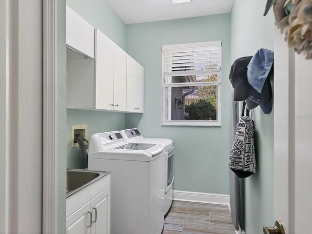 laundry room with cabinets, separate washer and dryer, light hardwood / wood-style flooring, and sink