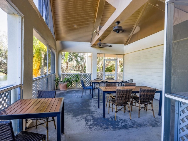 sunroom / solarium with vaulted ceiling with beams, a wealth of natural light, ceiling fan, and wooden ceiling