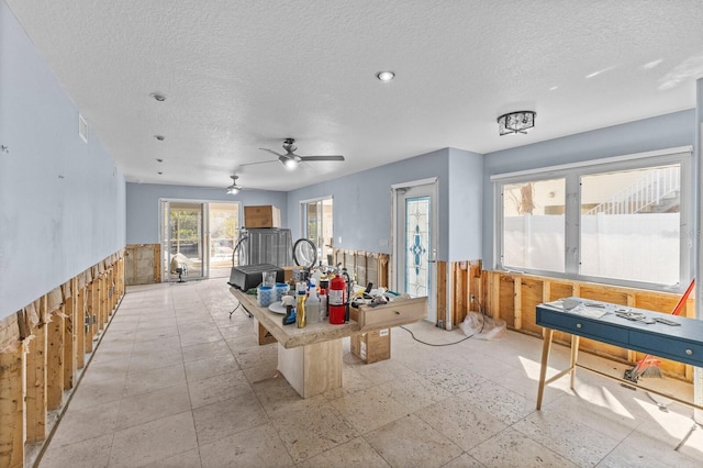 recreation room featuring ceiling fan and a textured ceiling