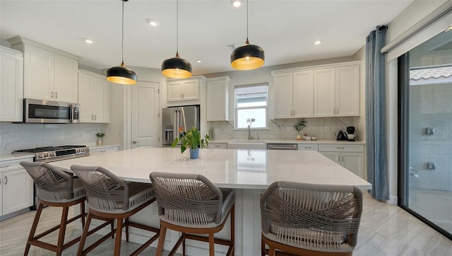 kitchen featuring premium appliances, a center island, and hanging light fixtures