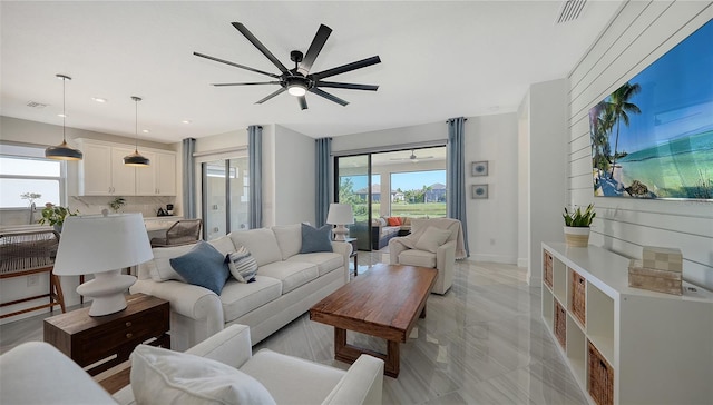 living room with ceiling fan and plenty of natural light