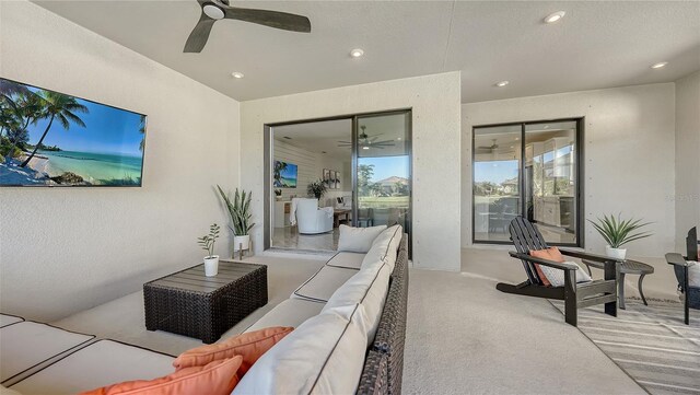 carpeted living room with a textured ceiling and ceiling fan