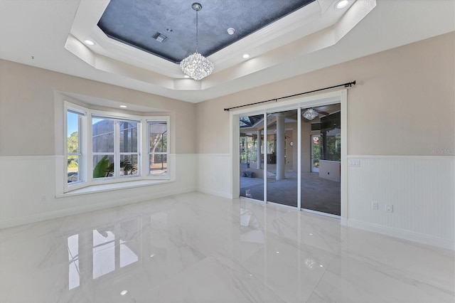 unfurnished room featuring a tray ceiling and a wealth of natural light