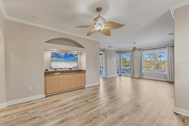 unfurnished living room with ornamental molding, ceiling fan, and light wood-type flooring