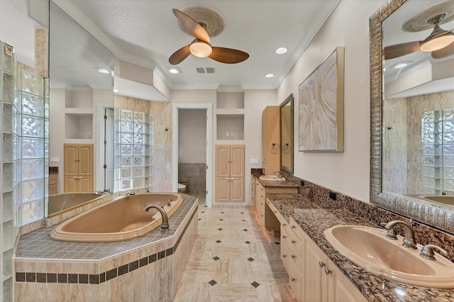 bathroom with toilet, ornamental molding, vanity, tiled tub, and ceiling fan