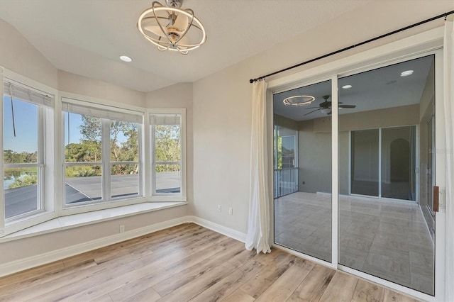 unfurnished sunroom with ceiling fan