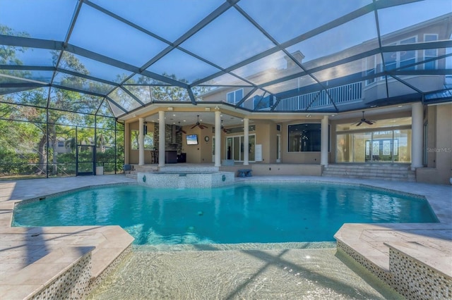 view of pool with a patio area, ceiling fan, and glass enclosure