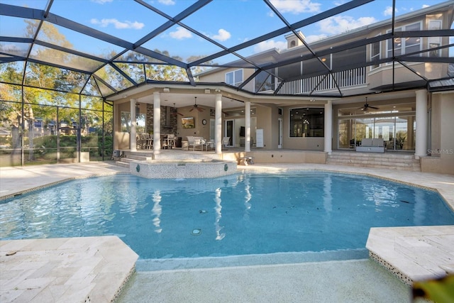 pool featuring ceiling fan, glass enclosure, and a patio area