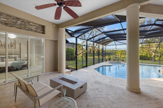 outdoor pool with a patio area, an outdoor fire pit, glass enclosure, and ceiling fan