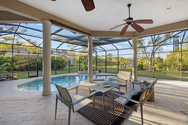 exterior space with glass enclosure, a ceiling fan, and an outdoor pool