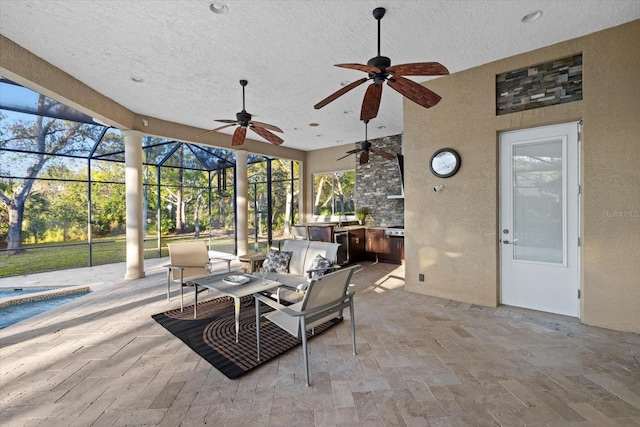 view of patio / terrace featuring ceiling fan, glass enclosure, an outdoor kitchen, and an outdoor pool