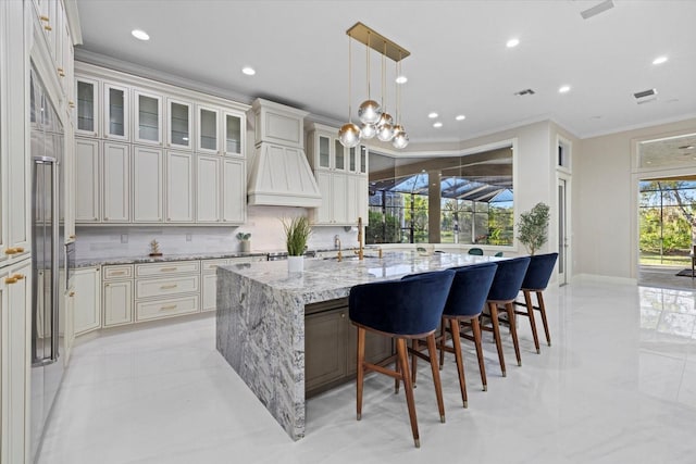 kitchen with a sink, visible vents, decorative backsplash, and crown molding