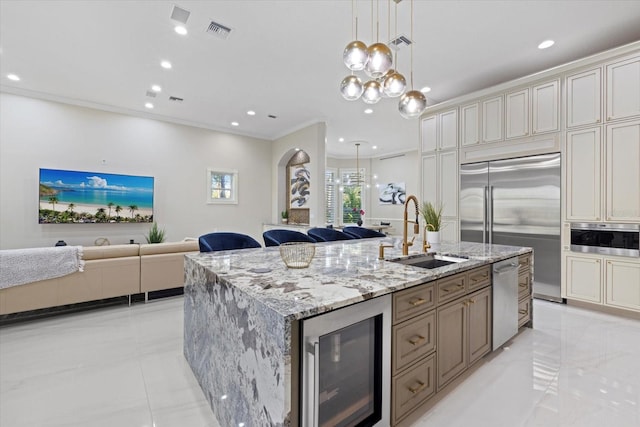 kitchen with wine cooler, stainless steel appliances, a sink, open floor plan, and a center island with sink