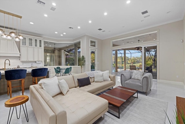 living area featuring baseboards, recessed lighting, visible vents, and crown molding