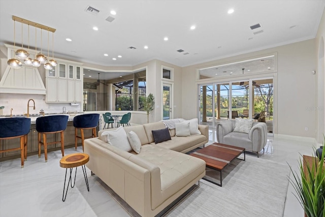 living room with recessed lighting, visible vents, baseboards, and ornamental molding