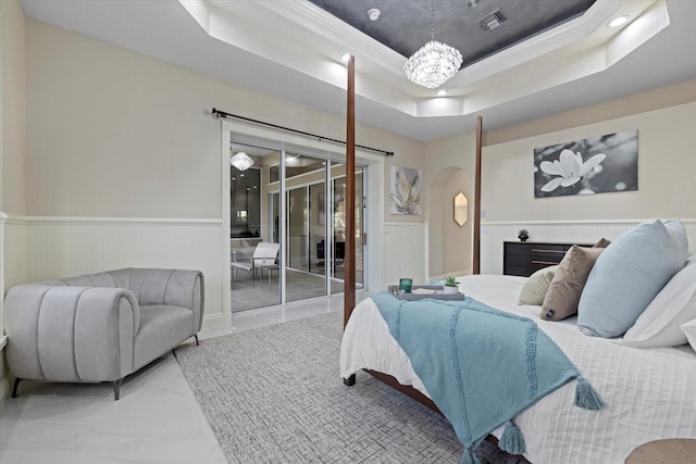 bedroom with arched walkways, a wainscoted wall, visible vents, marble finish floor, and a tray ceiling