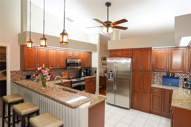 kitchen with sink, stainless steel appliances, light stone counters, high vaulted ceiling, and a kitchen bar