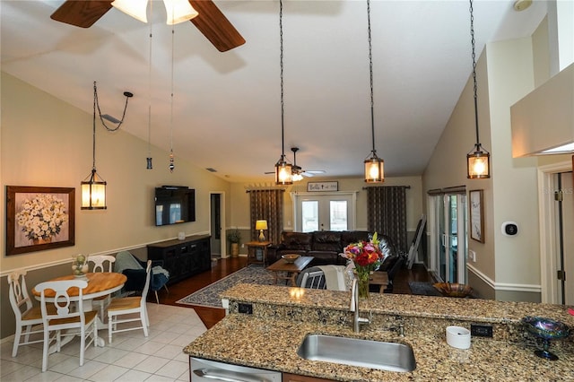 kitchen featuring french doors, sink, high vaulted ceiling, stainless steel dishwasher, and pendant lighting