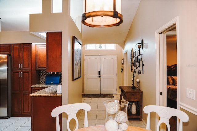 interior space with light tile patterned floors and vaulted ceiling