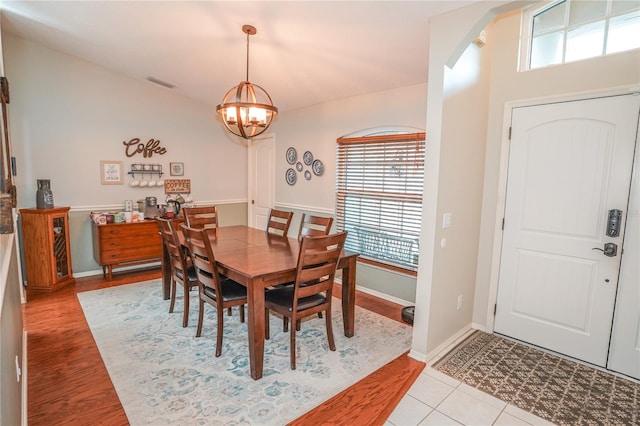 dining space featuring light wood-type flooring and a notable chandelier