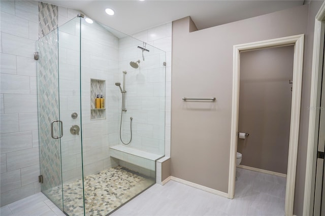 bathroom featuring tile patterned floors, a shower with shower door, and toilet