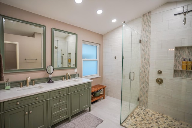 bathroom with vanity, a shower with door, and vaulted ceiling