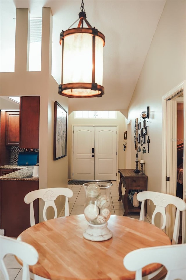 dining space with a high ceiling and light tile patterned flooring