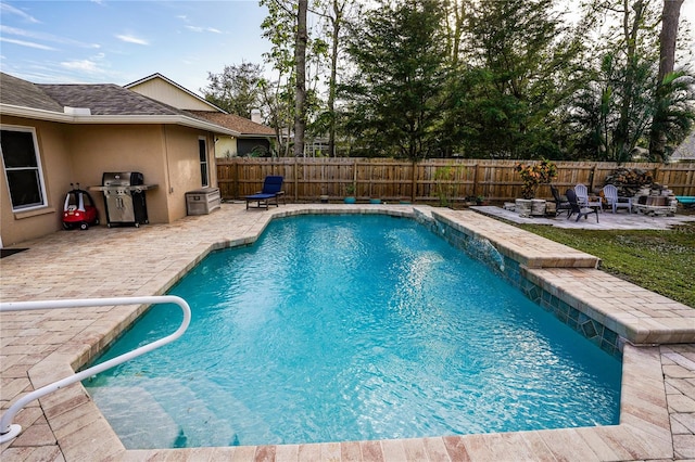 view of pool featuring a patio, an outdoor fire pit, and a grill