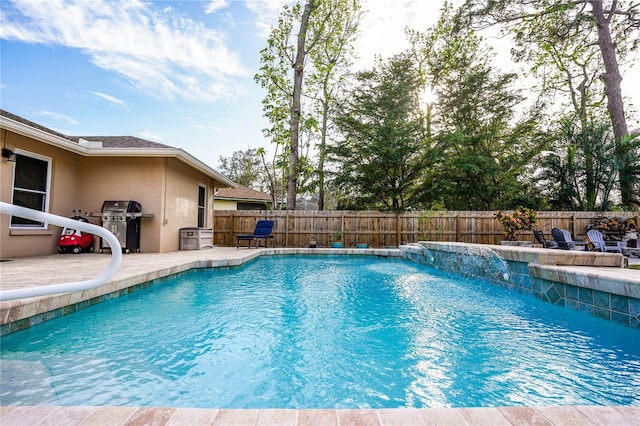 view of swimming pool featuring pool water feature and area for grilling