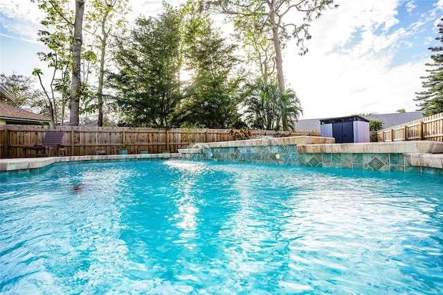 view of swimming pool with pool water feature and a storage shed