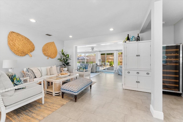 living room with ceiling fan, light tile patterned floors, and beverage cooler