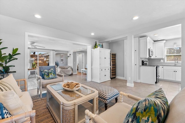 tiled living room featuring wine cooler and ceiling fan