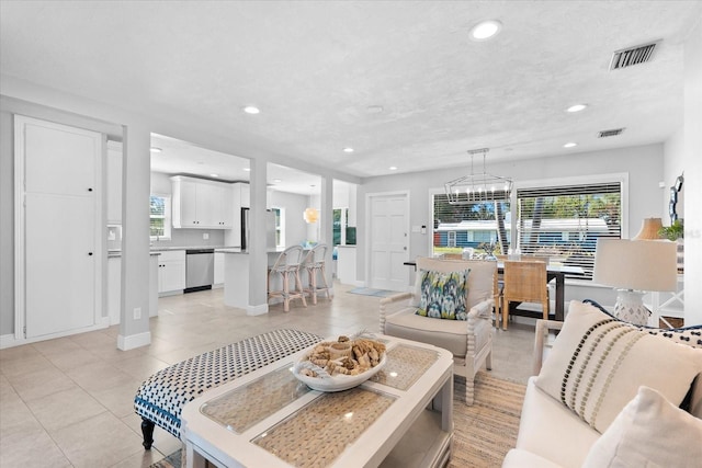 tiled living room featuring a notable chandelier