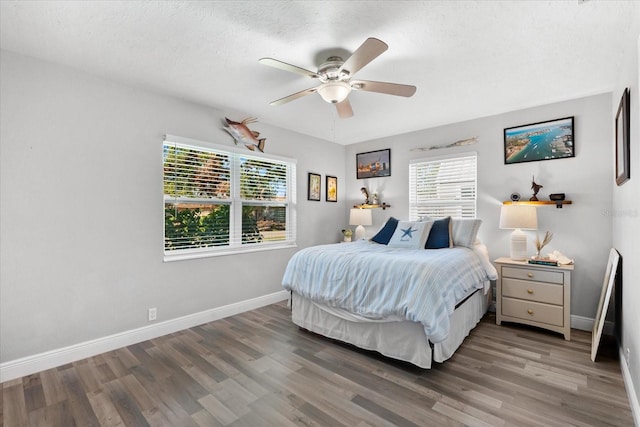 bedroom with a textured ceiling, hardwood / wood-style flooring, and ceiling fan