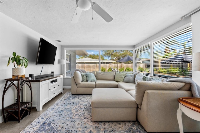 living room with ceiling fan and a textured ceiling